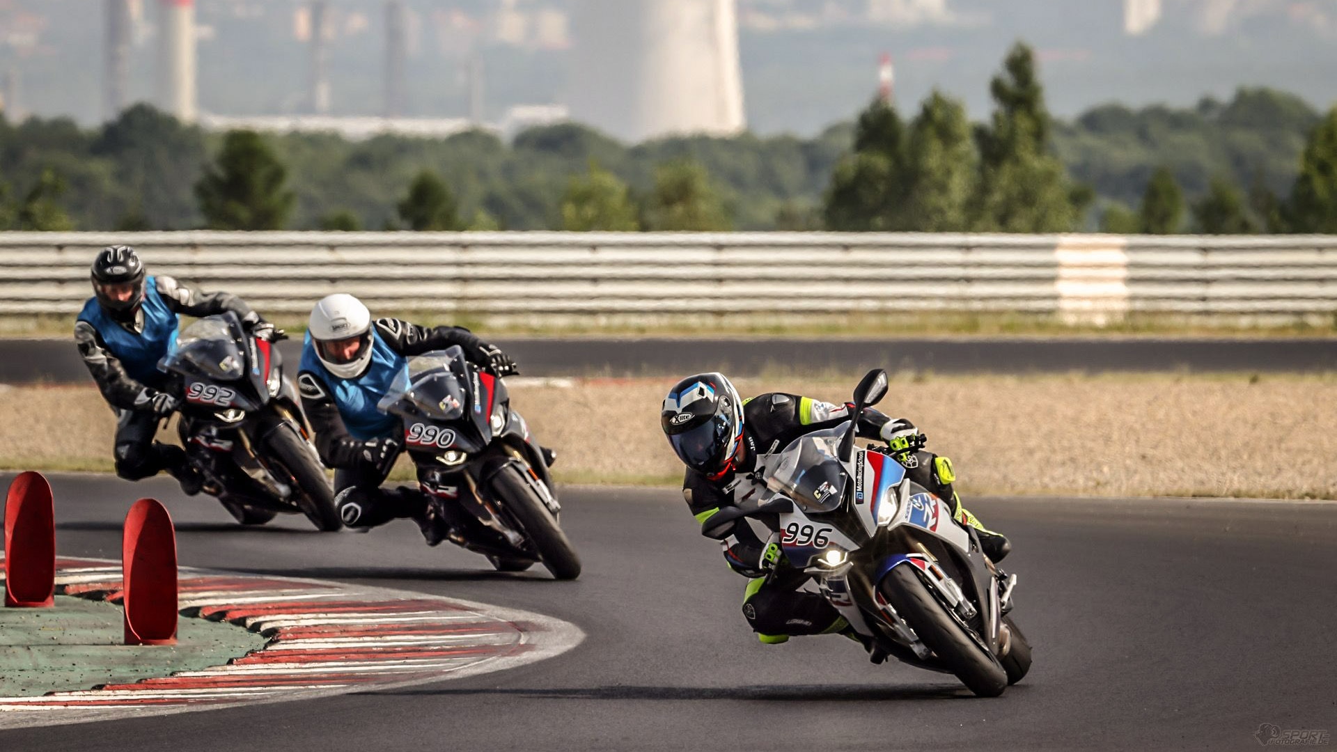 Tři motocyklisté při tréninku na závodním okruhu