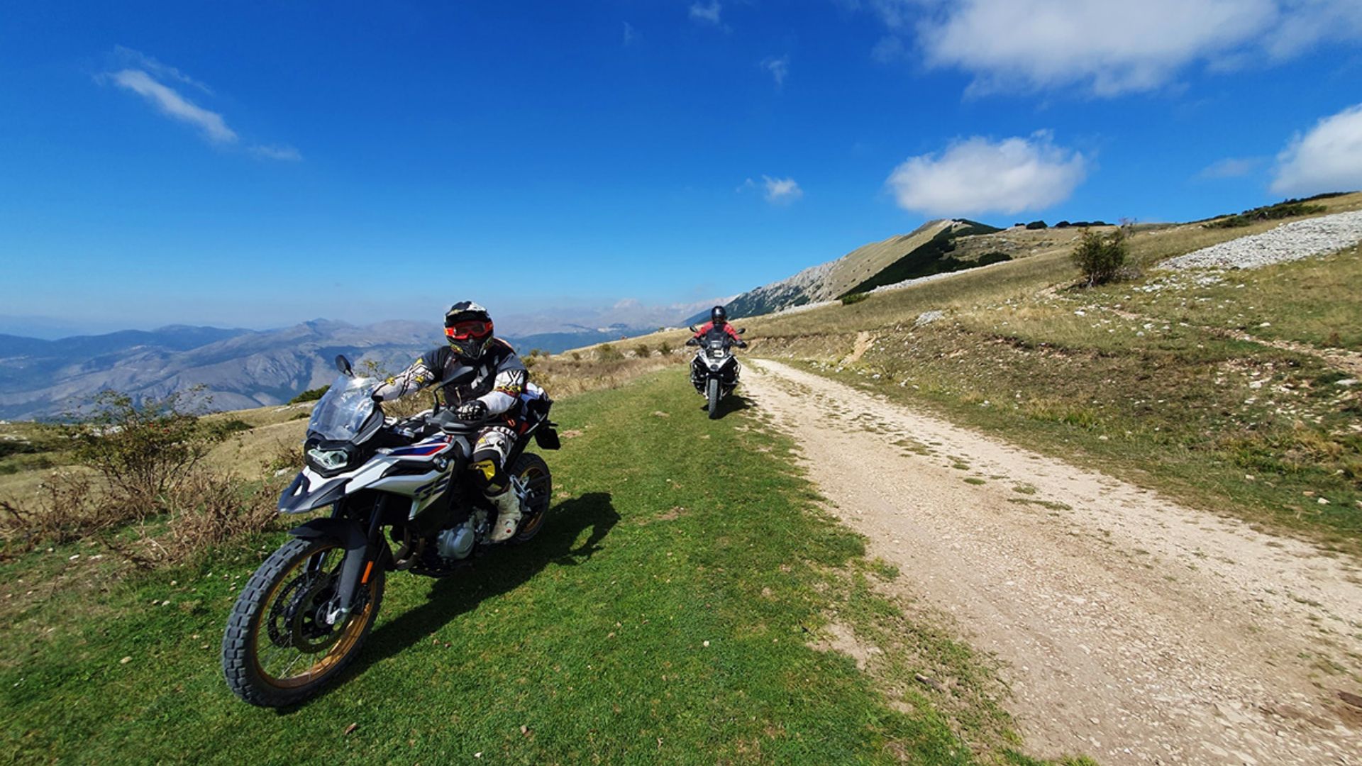 Lidé na motorkách BMW v horách